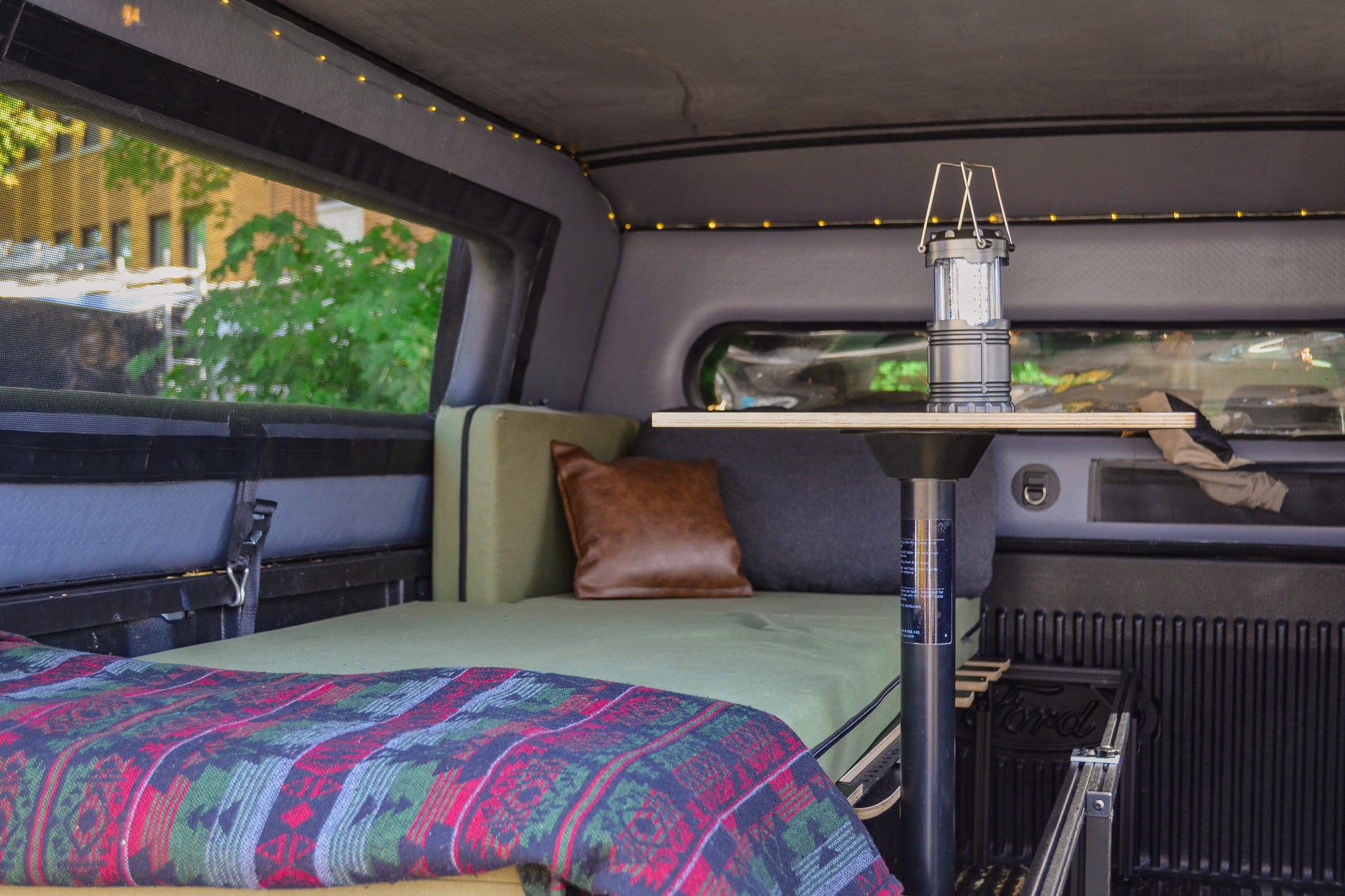 Single bed fully set up inside the pickup truck camper box.