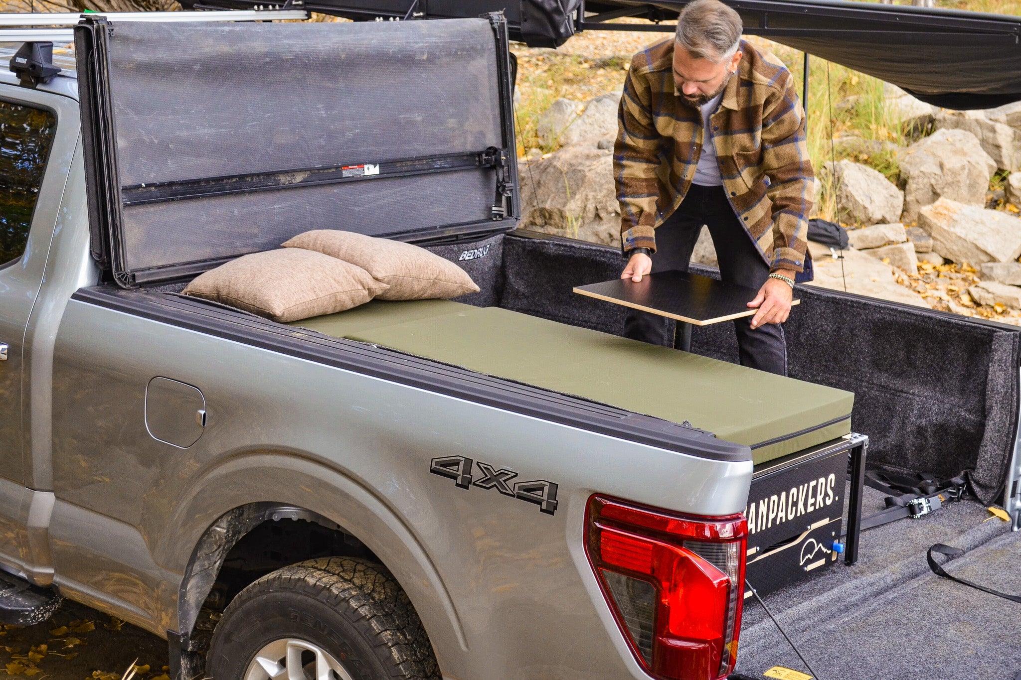 Table setup with single bed inside the pickup truck camper box.